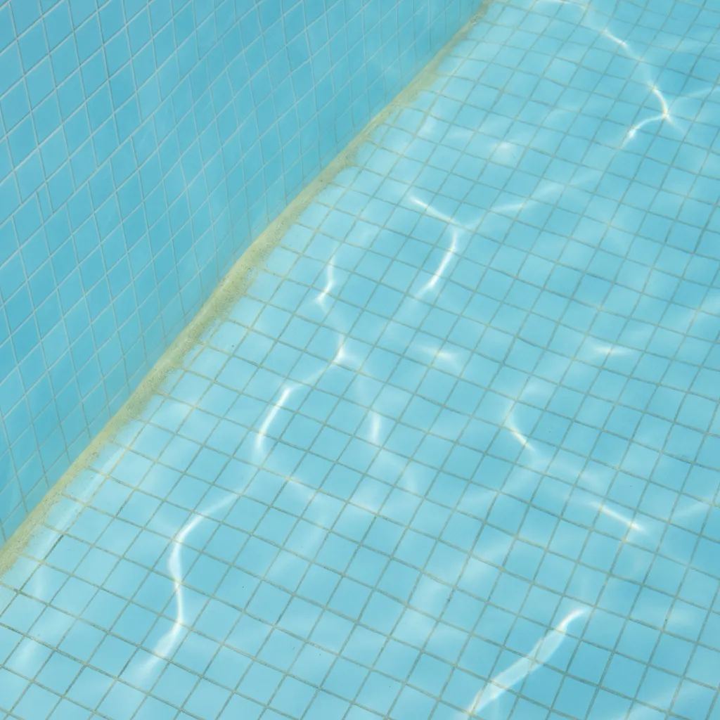 Paroi de piscine avec dépôt jaunâtre au fond, eau claire