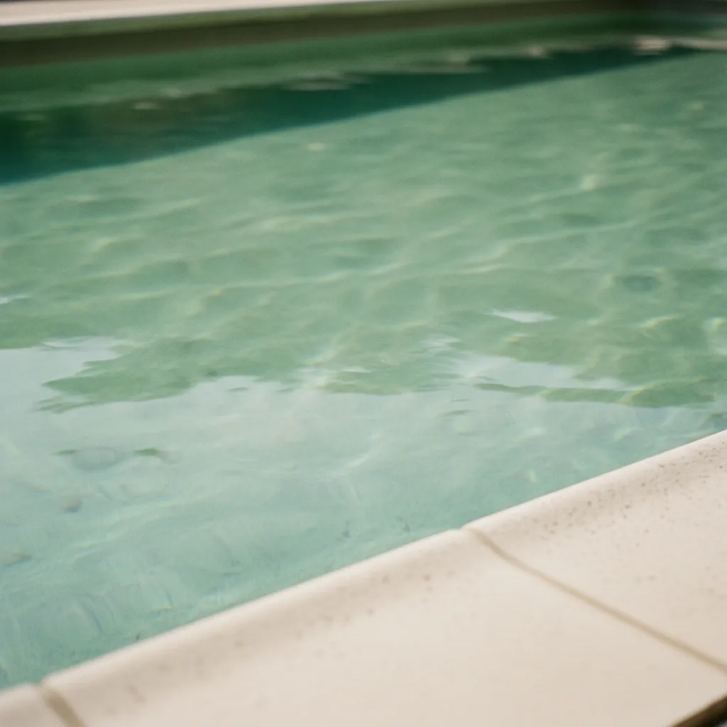 Surface d'une piscine à l'eau trouble sous la lumière du matin